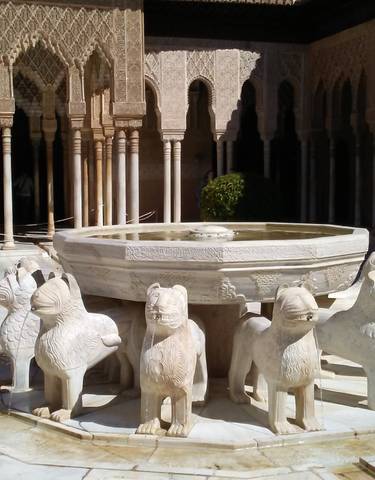 Stone fountain with lion statues in a courtyard.