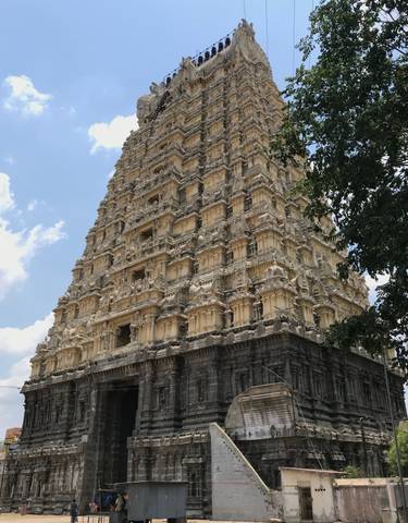 Ornate temple tower with detailed carvings against a blue sky.