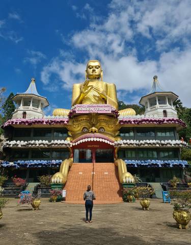 Golden Buddha statue atop a decorative temple entrance.