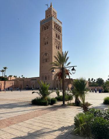 Tall mosque with palm trees on a sunny day.