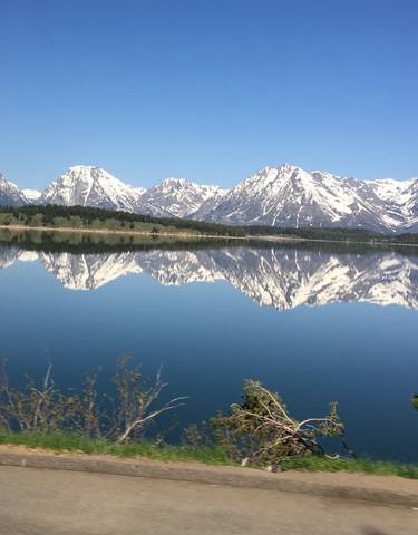 Snow-capped mountains reflecting in a calm lake.