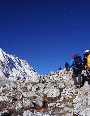 People trekking in a snowy mountainous landscape.
