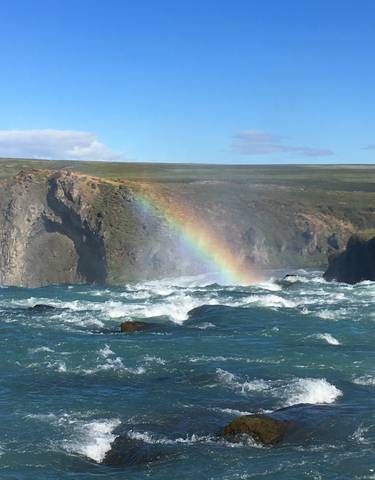 Rainbow over a river with cliffs