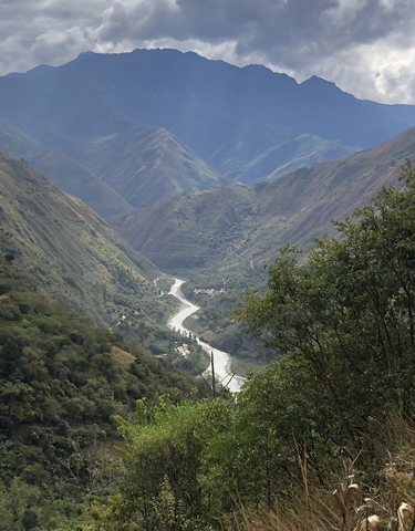 Valley with a winding river surrounded by green mountains.
