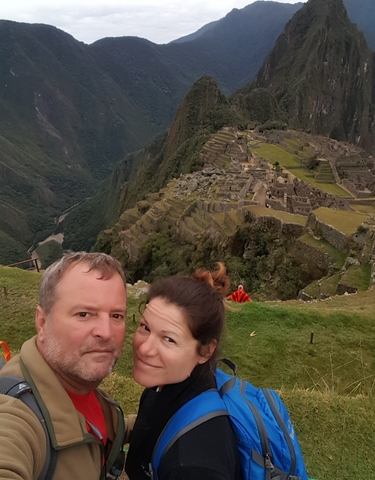 Couple posing with the ruins of Machu Picchu in the background.