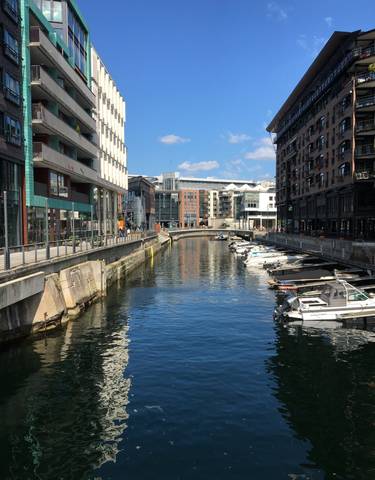 Modern waterfront area with boats and buildings.