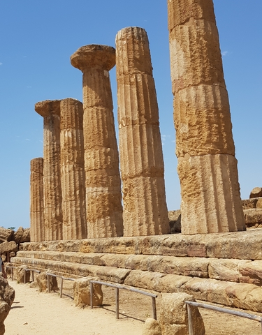 Ancient stone columns under a clear sky.