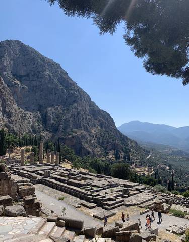 Ruins of an ancient temple among mountains and trees.