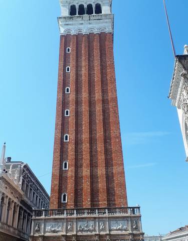 Tall brick bell tower with a blue sky background.