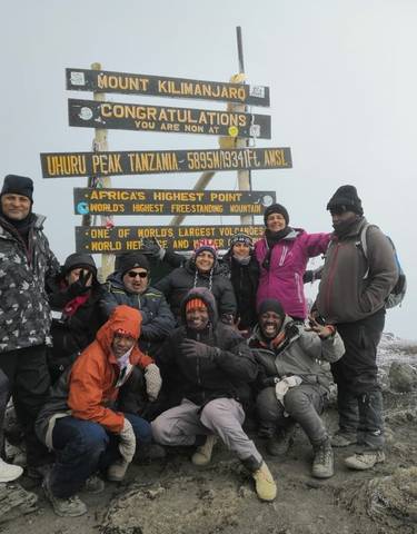 Group of climbers at the summit of Mount Kilimanjaro.