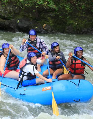 Group white-water rafting in a river.