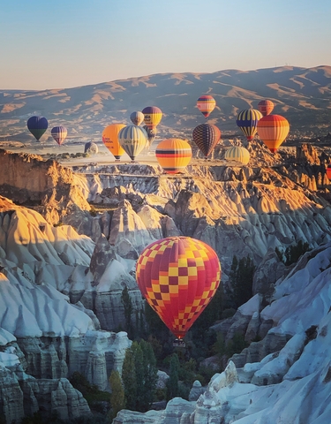Vibrant hot air balloons floating over unique rock formations.