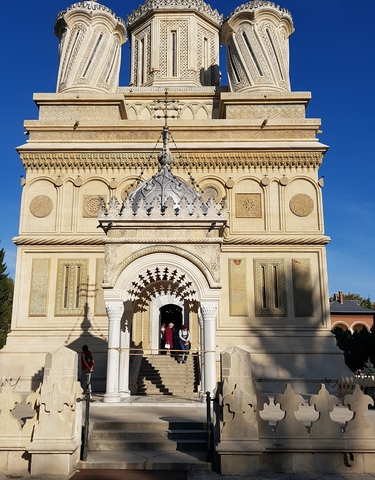 Ornate building facade with detailed carvings and an entrance.