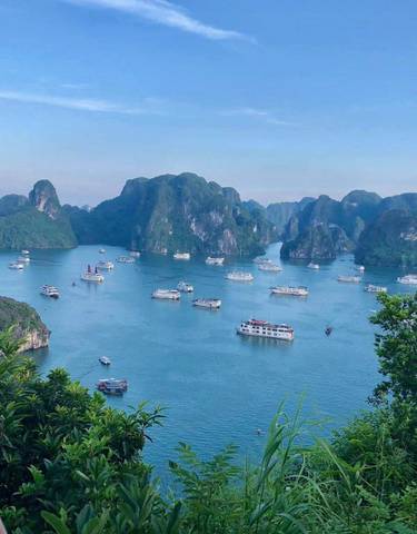 Panoramic view of Halong Bay with many boats and limestone karsts.