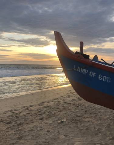 Boat on beach during a sunset with a visible inscription.