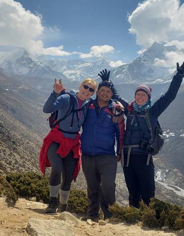Group of hikers posing with mountains in the background.