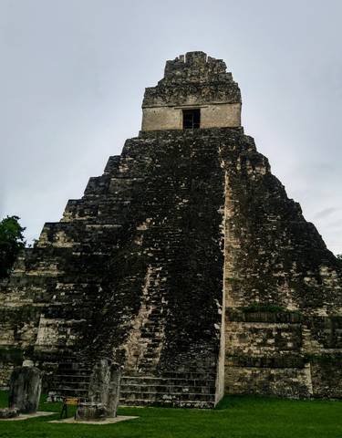 Large ancient pyramid structure against a cloudy sky.