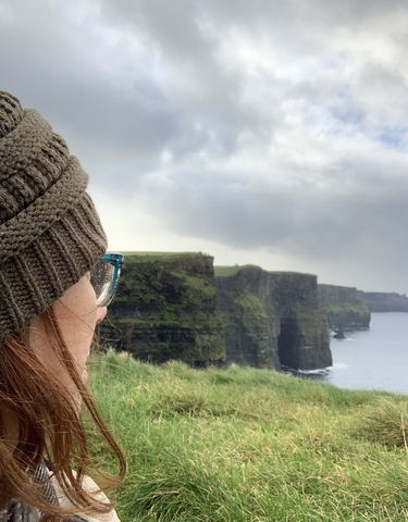 Woman looking at the Cliffs of Moher.
