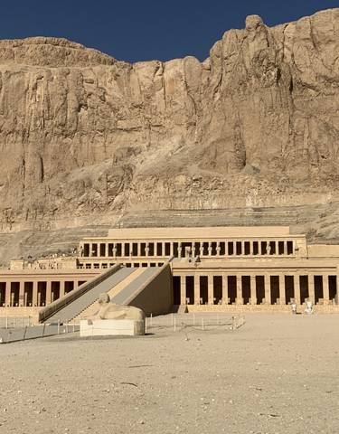 Ancient Egyptian temple with columns against a rocky backdrop.