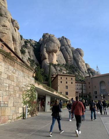 Building facade against a rugged mountain backdrop.