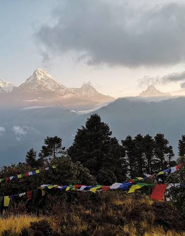 Snow-capped mountains with colorful prayer flags in the foreground.