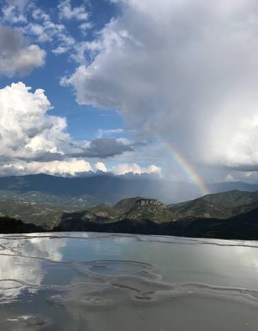 Stunning view of a landscape with a rainbow and mountains.
