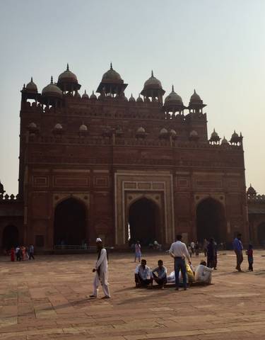 Historic gate with people walking in front.