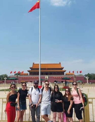 Group posing with the Forbidden City's entrance in the background.