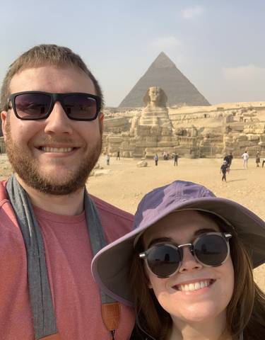 Couple posing in front of the Sphinx and pyramids.