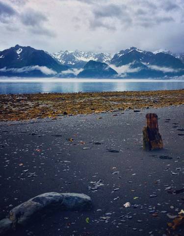 A serene lake with mountains and mist in the background.