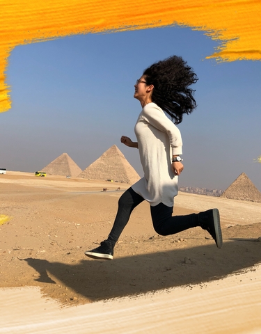 Person running with pyramids in the background.