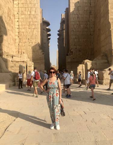 Tourists walking through a temple with hieroglyphs in Egypt.