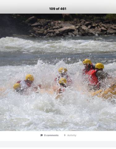 People white-water rafting on a river with rapids.