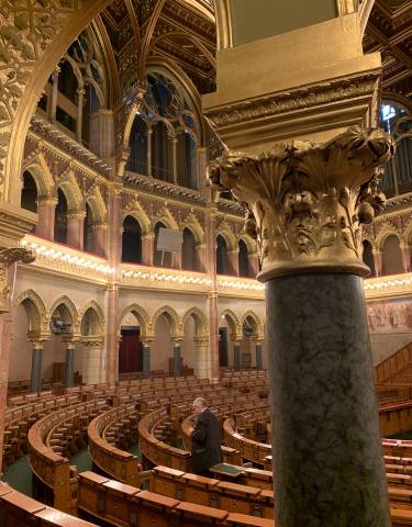 Luxurious interior of a grand hall with ornate columns and arches.