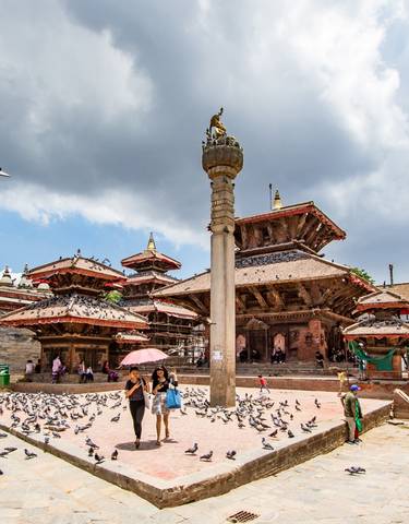 Bustling square with ancient temples and pigeons in Kathmandu.