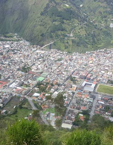 Aerial view of a city nestled in a valley surrounded by mountains.