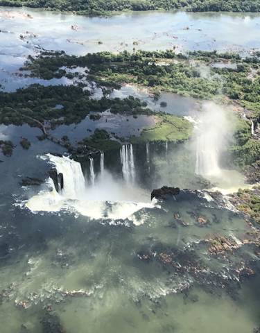 Aerial view of Iguazu Falls surrounded by lush greenery.