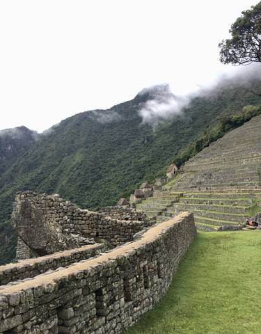 Terraces and ruins of Machu Picchu with tourists exploring.