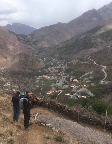 Panoramic view of mountain village surrounded by hills.