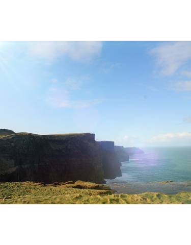 The Cliffs of Moher against the ocean on a clear day.