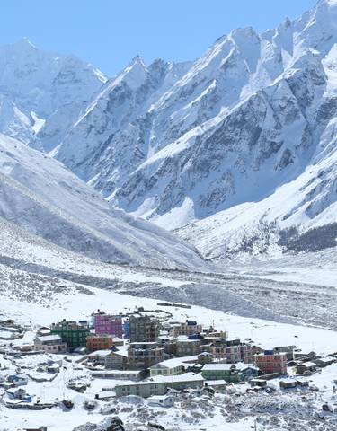 Snow-covered village nestled in a dramatic mountain landscape.