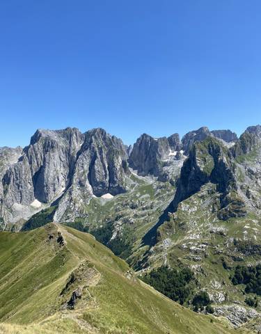 Mountainous landscape with rocky peaks and green valleys.
