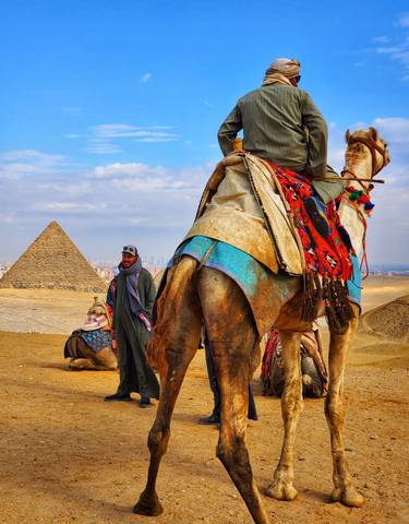 Man with a camel at the pyramids.
