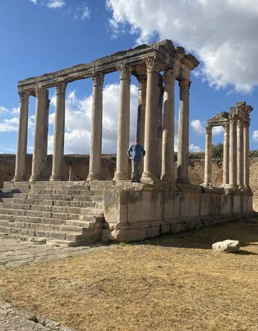 Ruins of an ancient structure with a person standing on the steps.