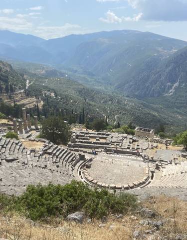 Ancient theater ruins surrounded by mountains.