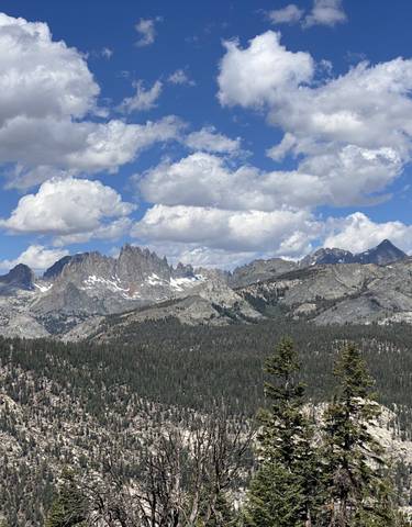 Mountain range with snow-capped peaks under blue skies.