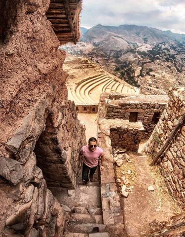 Person standing amidst ancient stone ruins.