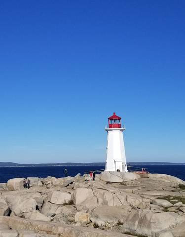Lighthouse on a rocky coast with the ocean in the background.