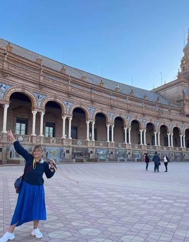 Person posing in front of a historical building