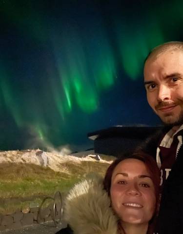 A couple with northern lights in the background
